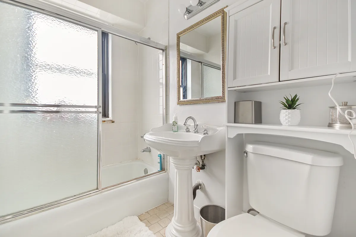 345 East 80th Street, Unit 17J Manhattan, NY 10075 - Photo 7 of 8 a bathroom with a sink toilet and shower