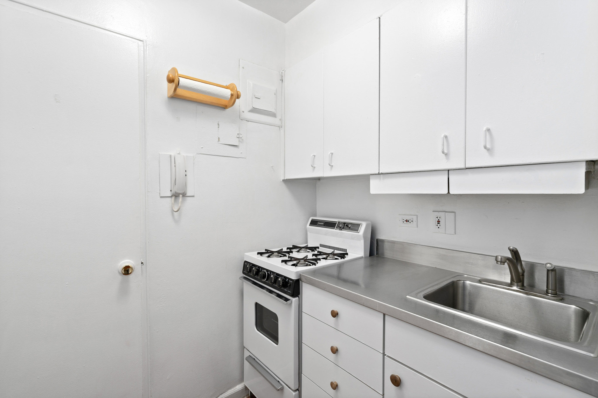 60 East 9th Street, Unit 235 Manhattan, NY 10003 - Photo 10 of 14 a kitchen with cabinets and appliances