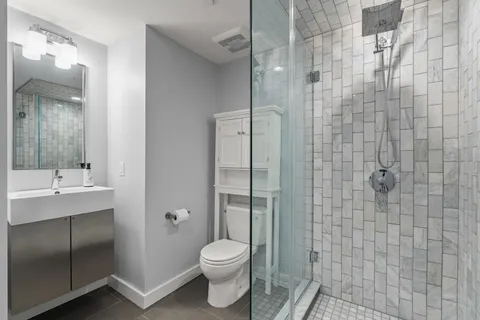 a bathroom with a toilet sink vanity and shower