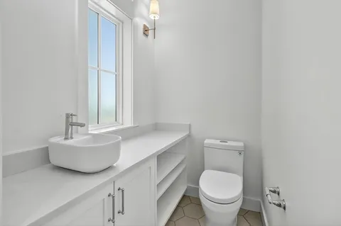 a bathroom with a granite countertop shower and a toilet