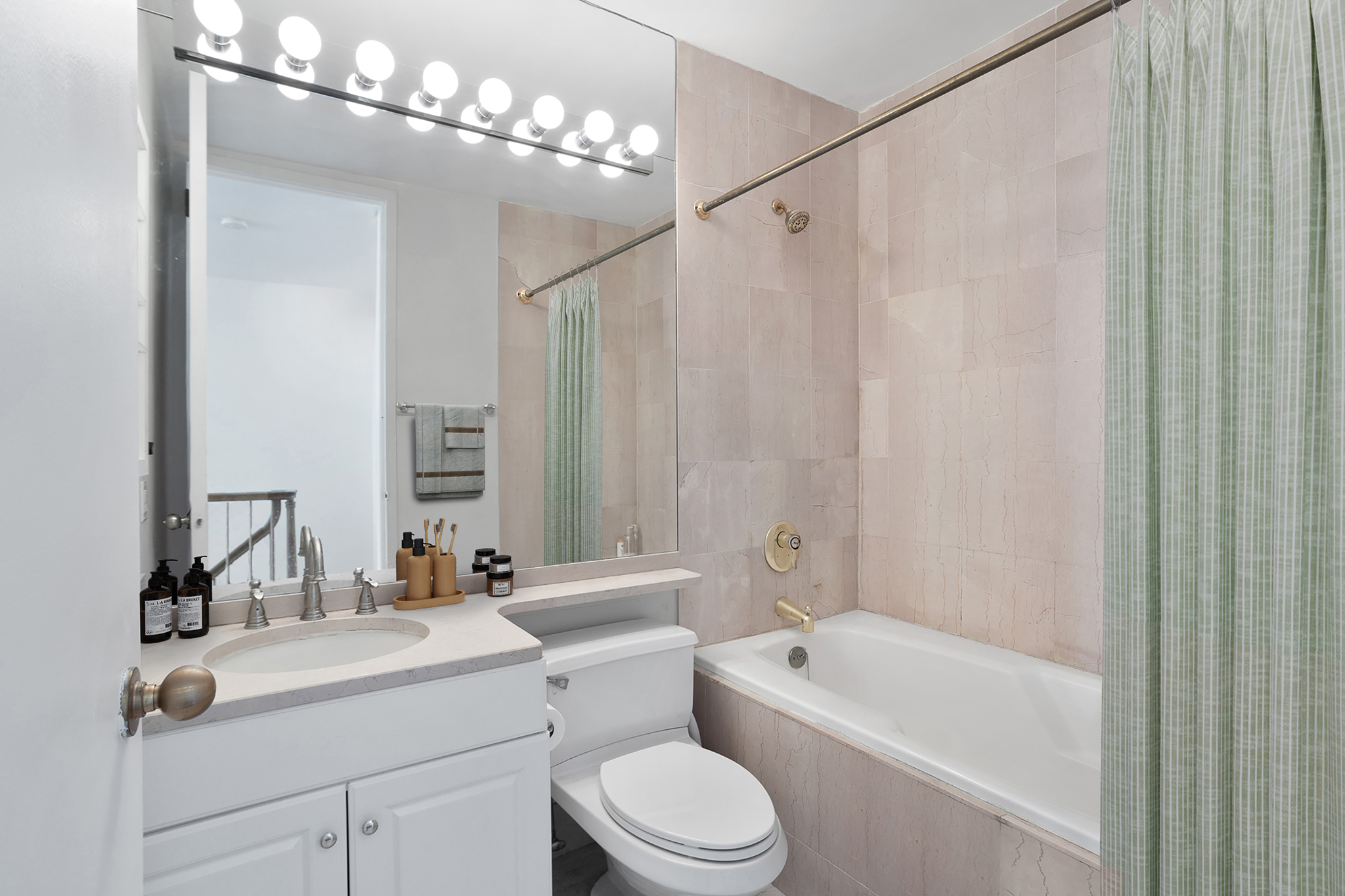21 South End Avenue, Unit 406 Manhattan, NY 10280 - Photo 9 of 16 a bathroom with a sink a toilet a mirror and shower