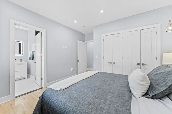 a spacious bedroom with a bed and wooden floor