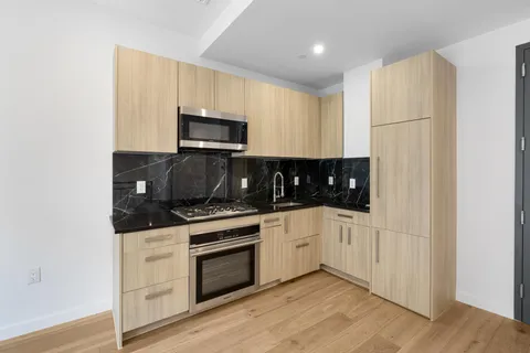 a kitchen with cabinets stainless steel appliances and wooden floor