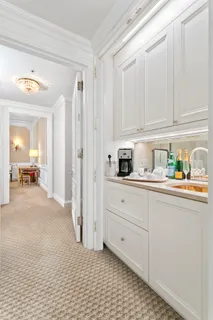 a kitchen with white cabinets and sink