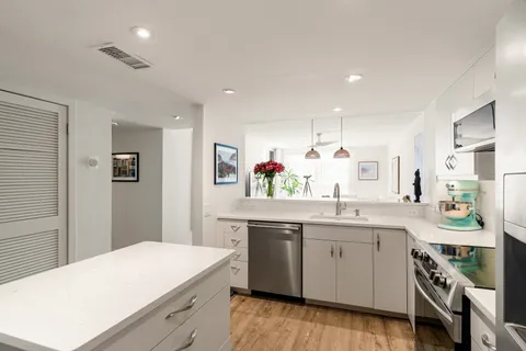 a kitchen with a sink a stove a refrigerator and white cabinets