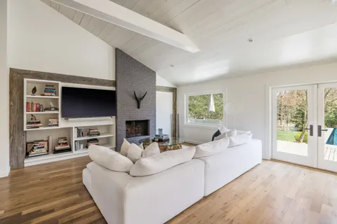 a living room with furniture a flat screen tv and a fireplace