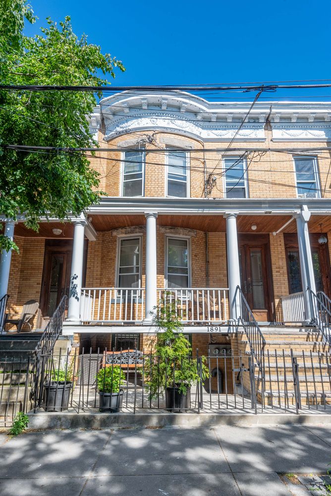 18-91 Stockholm Street, Unit 1 Queens, NY 11385 - Photo 5 of 5 a front view of a residential apartment building with a yard