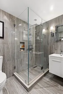 a bathroom with a shower a toilet and sink