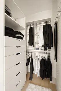 a view of walk in closet with clothes and shoes