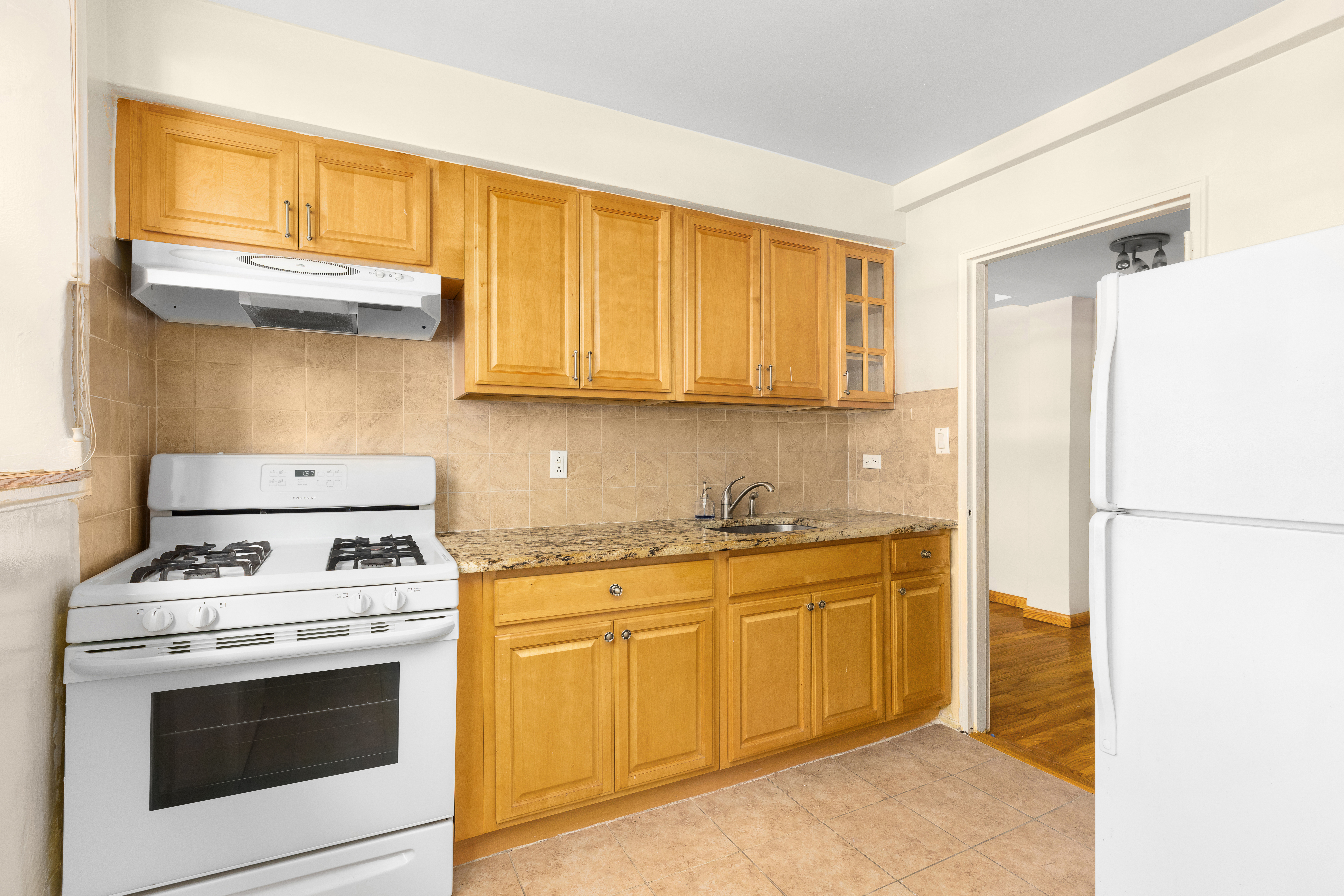 310 Beverley Road, Unit LB Brooklyn, NY 11218 - Photo 4 of 9 a kitchen with stainless steel appliances granite countertop a stove a sink and a microwave