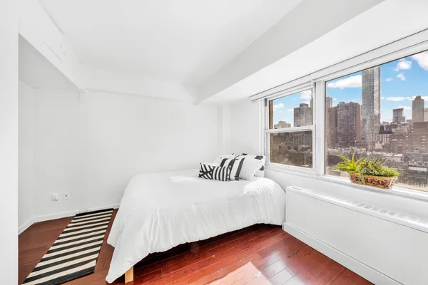 a bedroom with a bed and a large window
