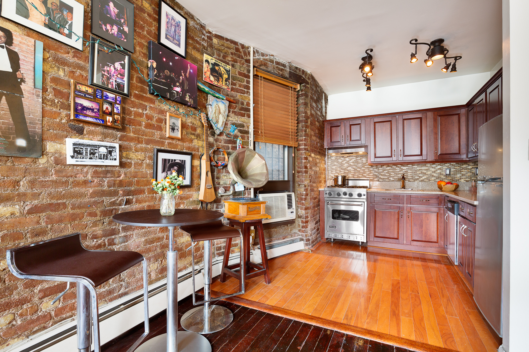 115 Charles Street, Unit 11 Manhattan, NY 10014 - Photo 3 of 7 a kitchen with stainless steel appliances kitchen island granite countertop a stove and cabinets