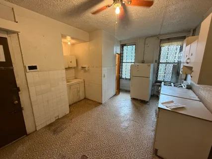 a view of a kitchen with fridge and workspace