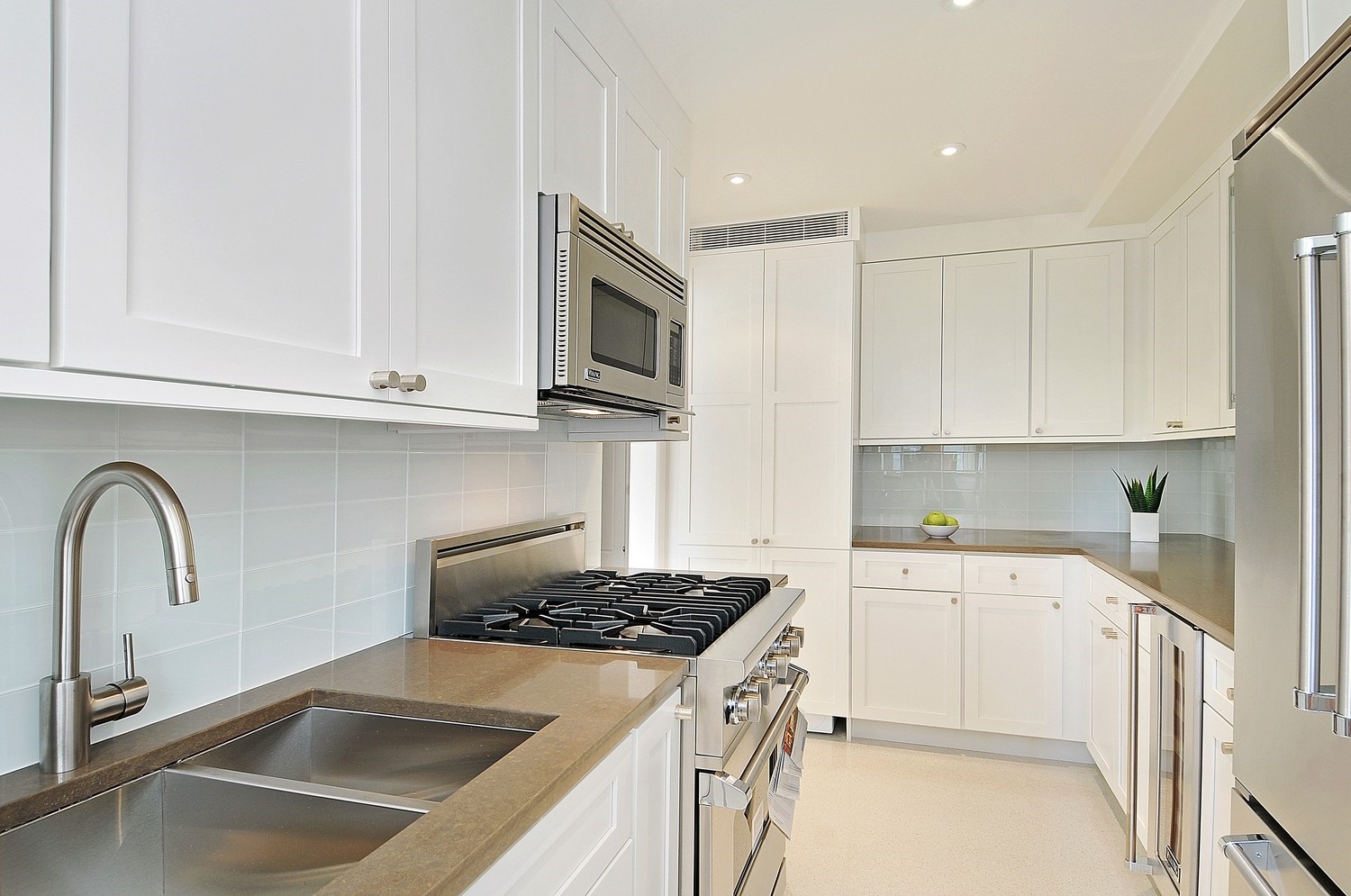 200 East 66th Street, Unit D804 Manhattan, NY 10065 - Photo 5 of 10 a kitchen with granite countertop a sink stainless steel appliances and cabinets