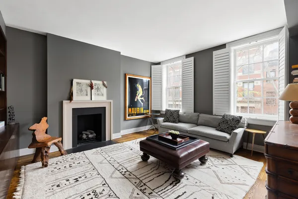 a living room with a fireplace and a rug