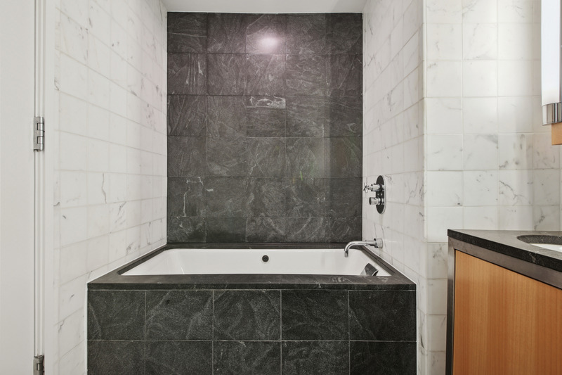 100 West 58th Street, Unit 5E Manhattan, NY 10019 - Photo 8 of 12 a bathroom with a bathtub and shower