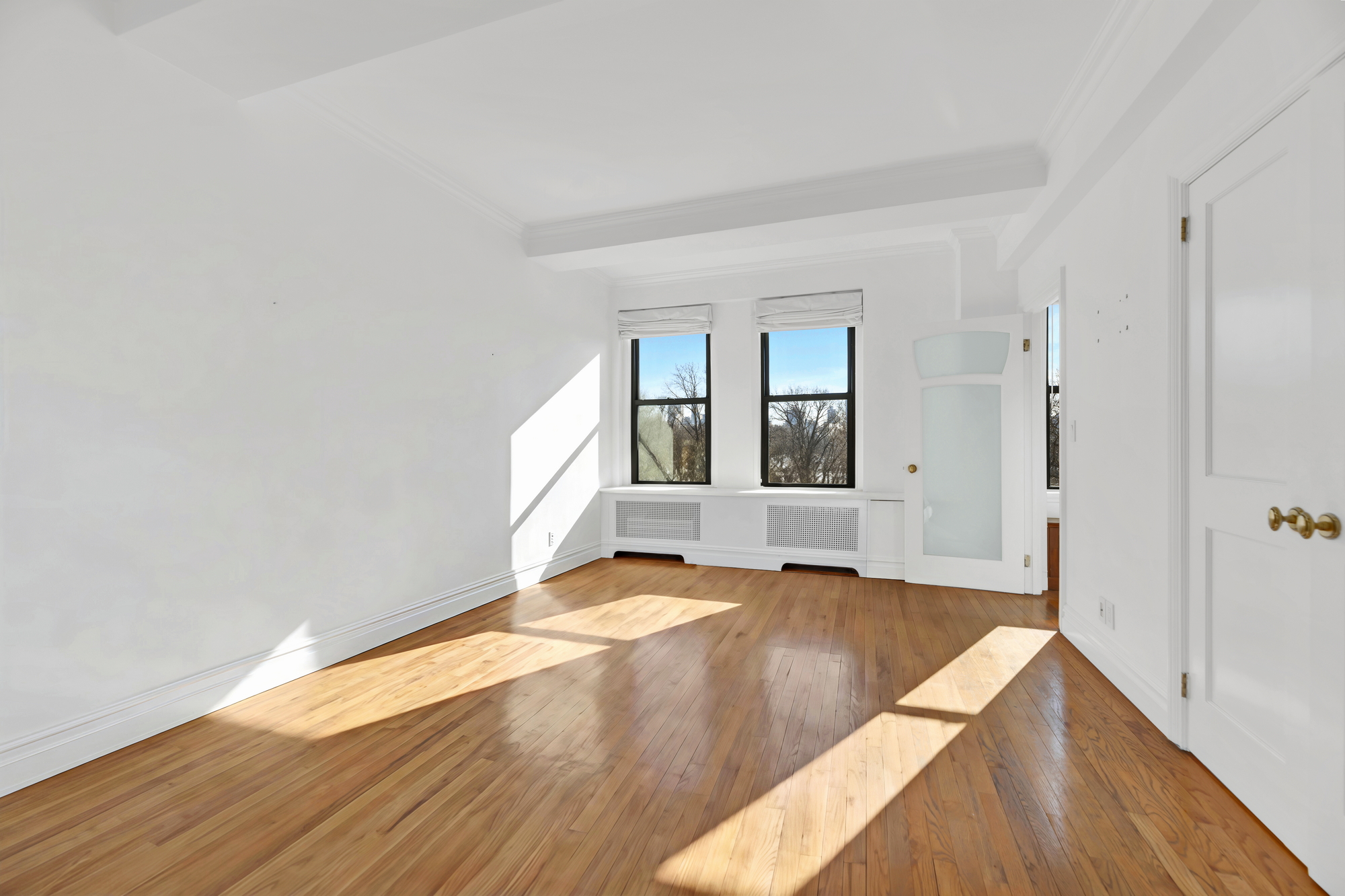 225 Central Park West, Unit 801 Manhattan, NY 10024 - Photo 12 of 21 a view of an empty room with wooden floor and a window