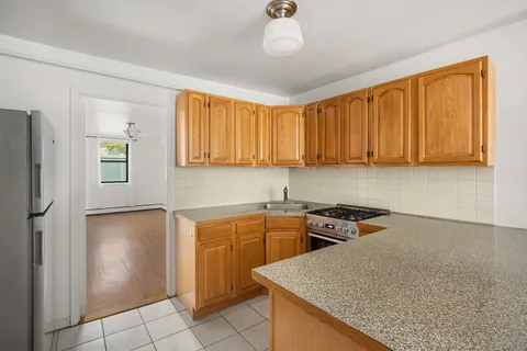a kitchen with stainless steel appliances granite countertop a sink window and cabinets