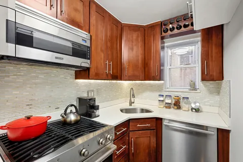 a kitchen with stainless steel appliances granite countertop a stove and cabinets