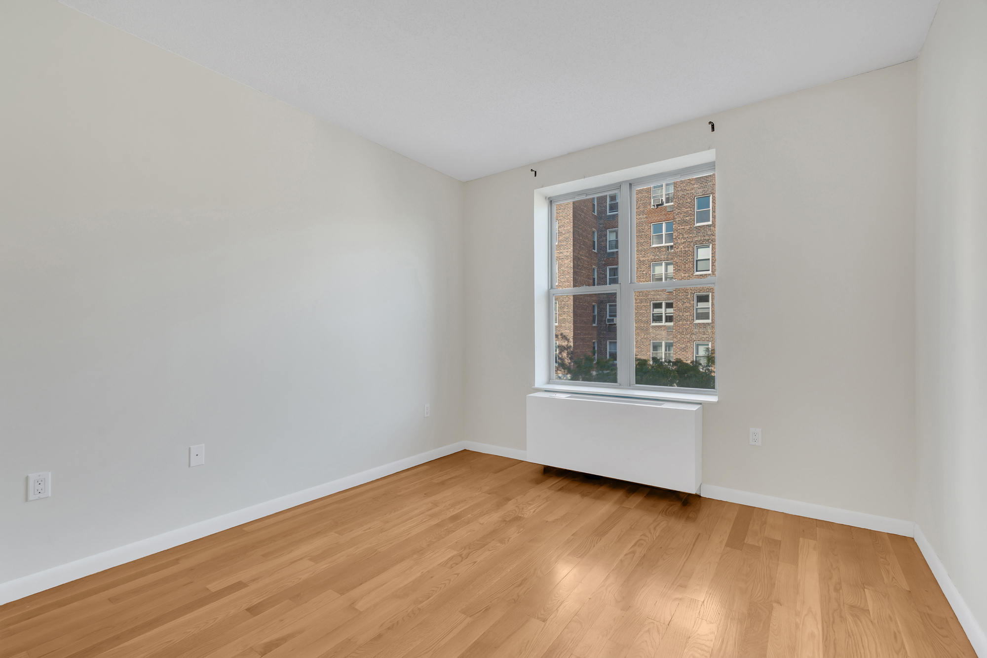 736 West 187th Street, Unit 502 Manhattan, NY 10033 - Photo 10 of 11 a view of an empty room with wooden floor and a window