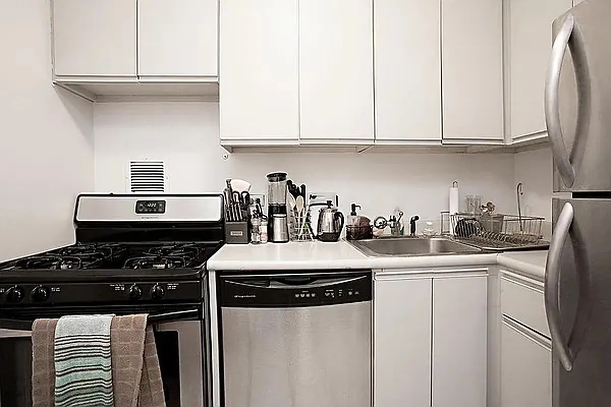 330 East 75th Street, Unit 4D Manhattan, NY 10021 - Photo 4 of 9 a kitchen with stainless steel appliances granite countertop a sink stove and cabinets