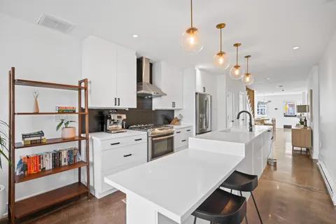 a large kitchen with white cabinets and stainless steel appliances