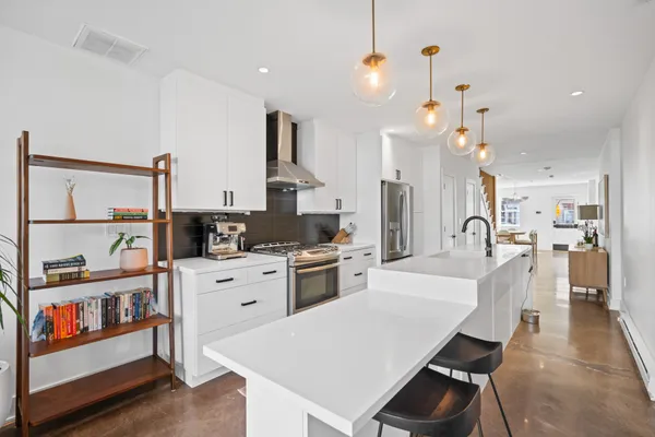 a large kitchen with white cabinets and stainless steel appliances