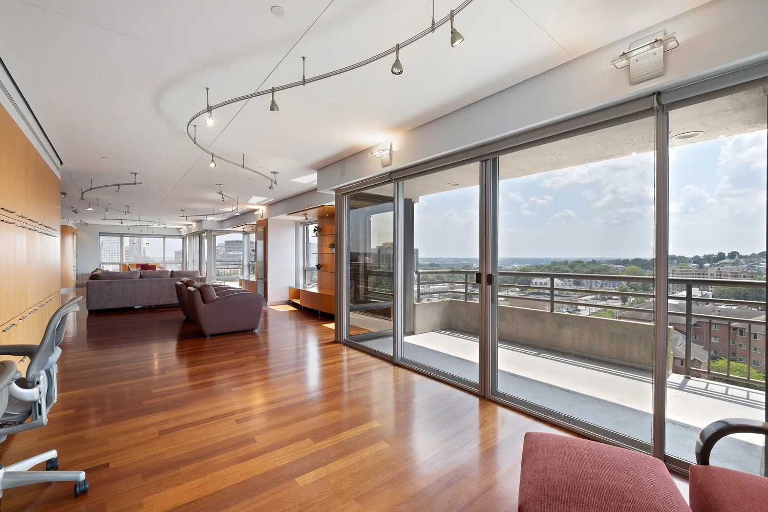 a living room with couches and dining table with wooden floor