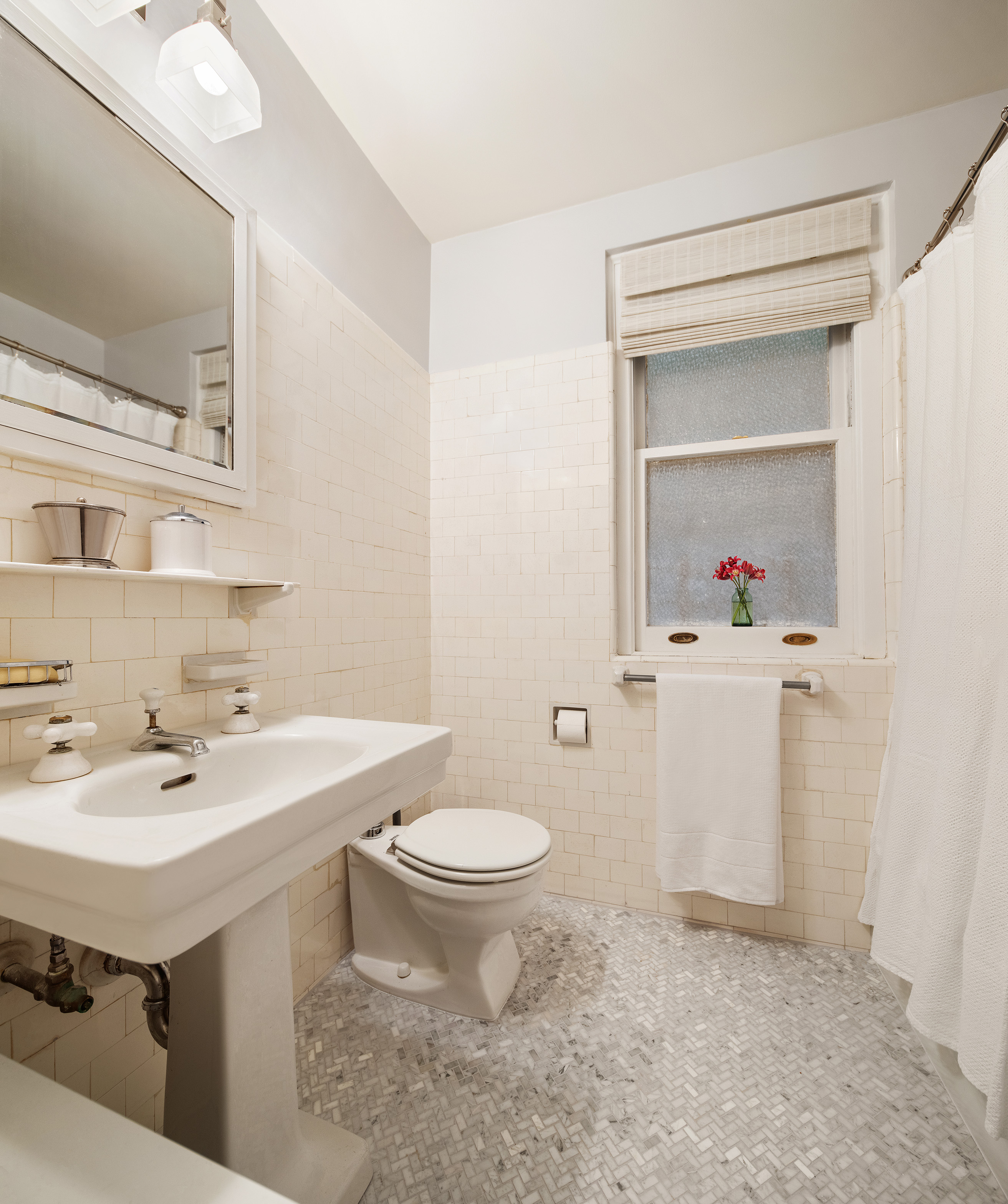 115 East 86th Street, Unit 22 Manhattan, NY 10028 - Photo 9 of 16 a bathroom with a sink toilet and mirror