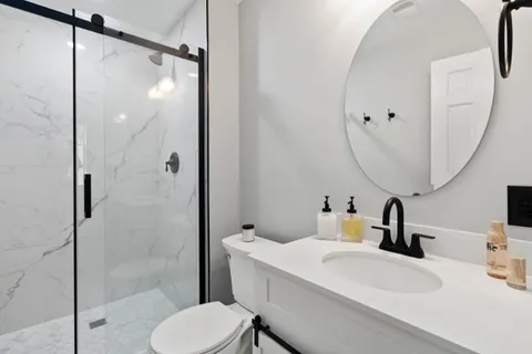 a bathroom with a sink a toilet and shower
