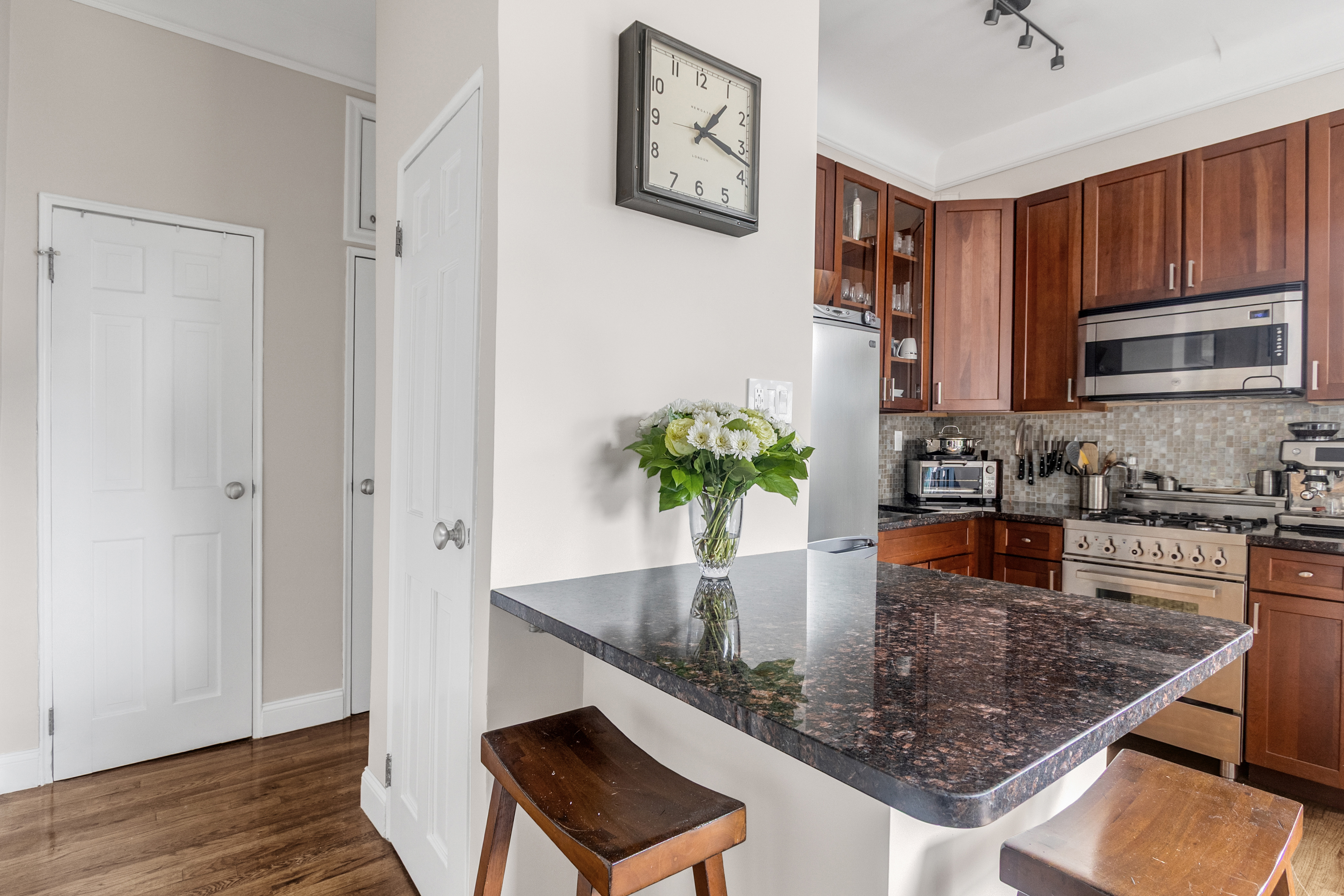 51 West 81st Street, Unit 9D Manhattan, NY 10024 - Photo 4 of 15 a kitchen with stainless steel appliances granite countertop a sink refrigerator and microwave