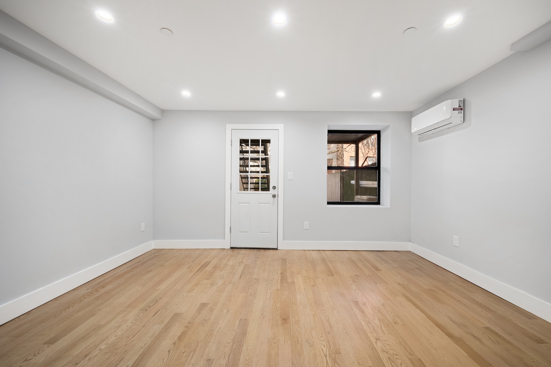 307 West 136th Street Manhattan, NY 10030 - Photo 20 of 26 a view of an empty room with wooden floor and a window