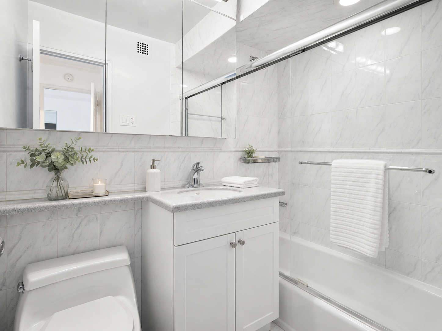 420 East 72nd Street, Unit 7L Manhattan, NY 10021 - Photo 5 of 10 a bathroom with a sink a toilet and mirror