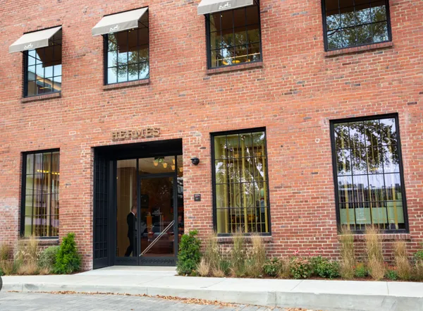 a view of a brick building that has a tree in front of it