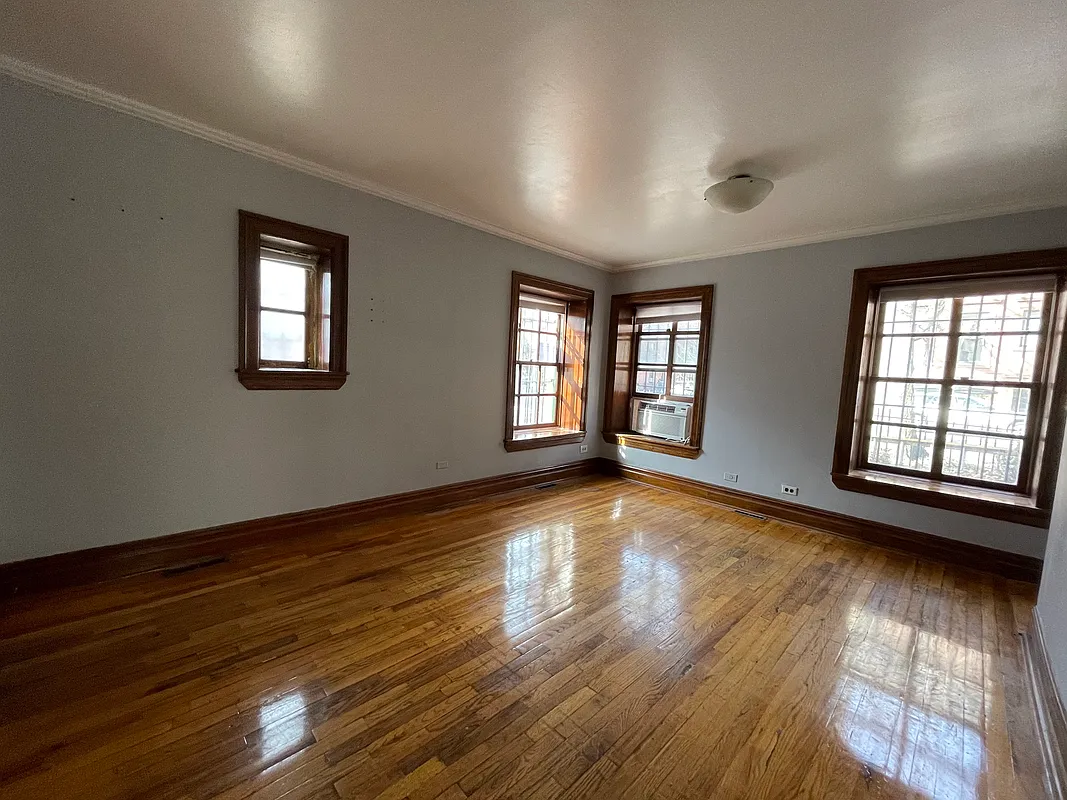 343 Carlton Avenue, Unit 1A Brooklyn, NY 11238 - Photo 1 of 6 a view of an empty room with wooden floor and a window