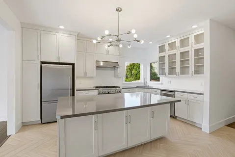 a kitchen with kitchen island granite countertop a refrigerator a sink and dishwasher