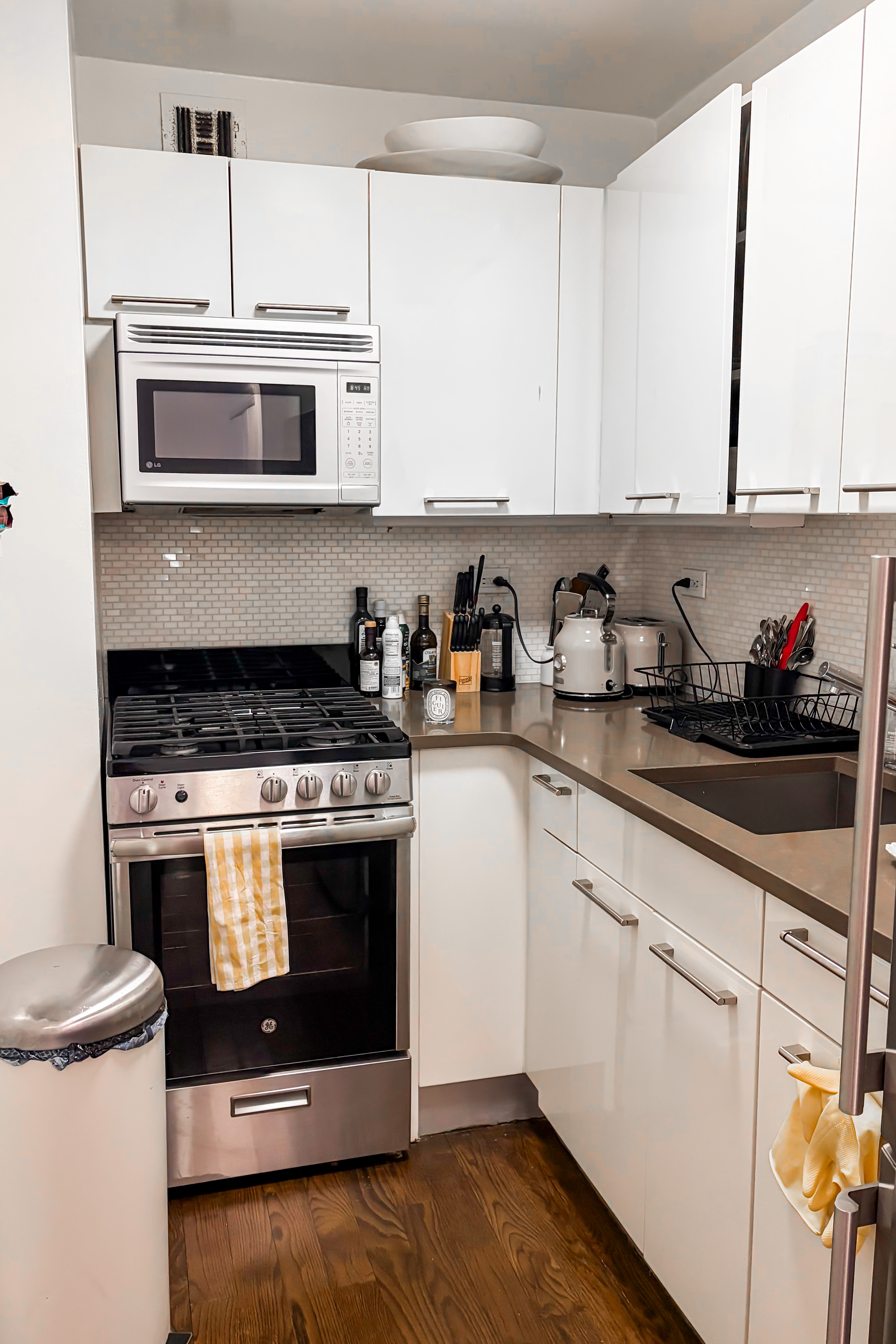 220 East 63rd Street, Unit 4N Manhattan, NY 10065 - Photo 4 of 13 a kitchen with granite countertop white cabinets and white appliances