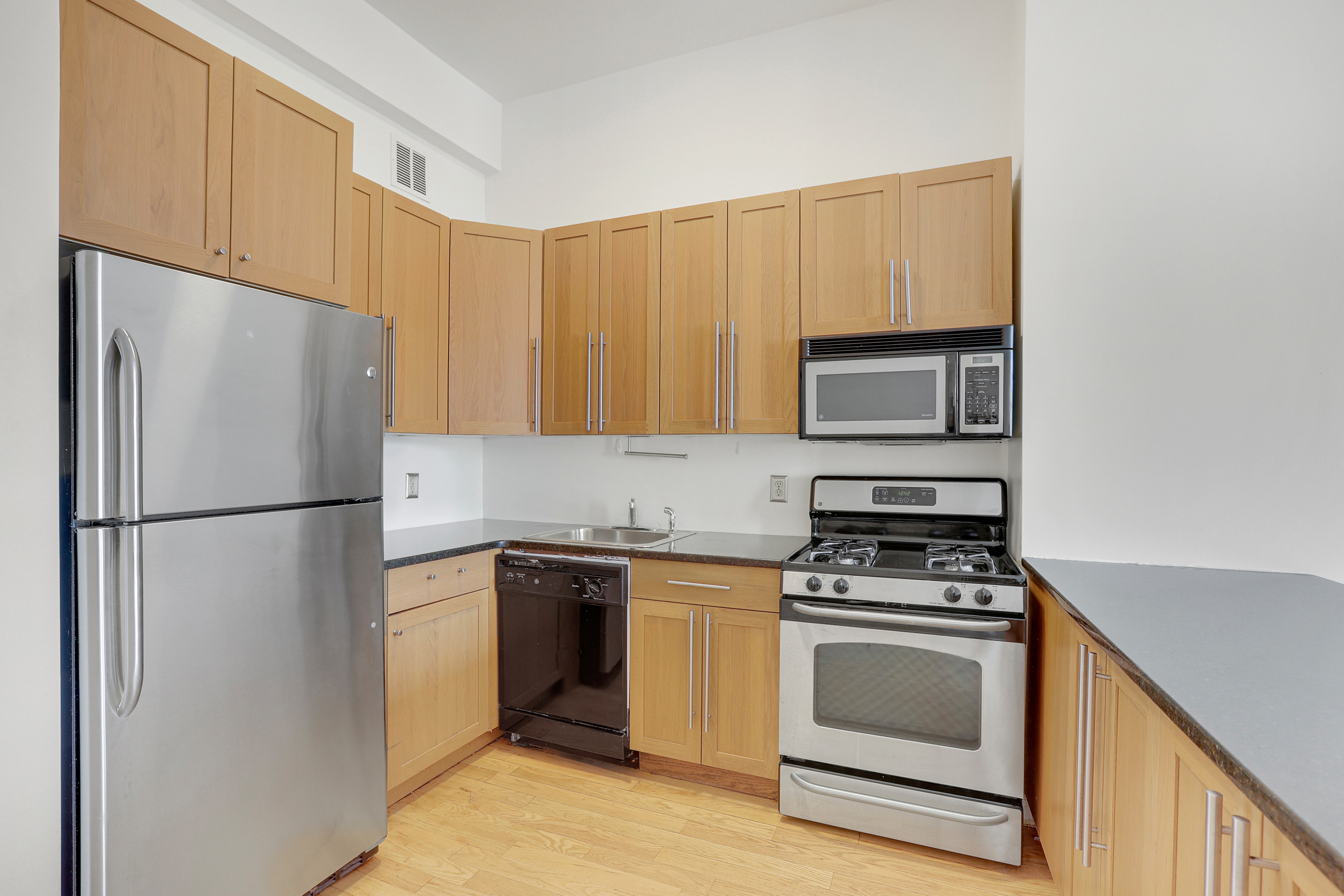 315 7th Avenue, Unit 10E Manhattan, NY 10001 - Photo 5 of 13 a kitchen with a refrigerator stove and microwave