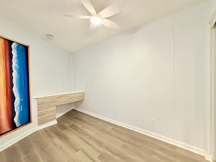 a view of an empty room with closet and a window