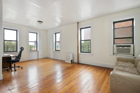 a view of livingroom with furniture hardwood floor and windows