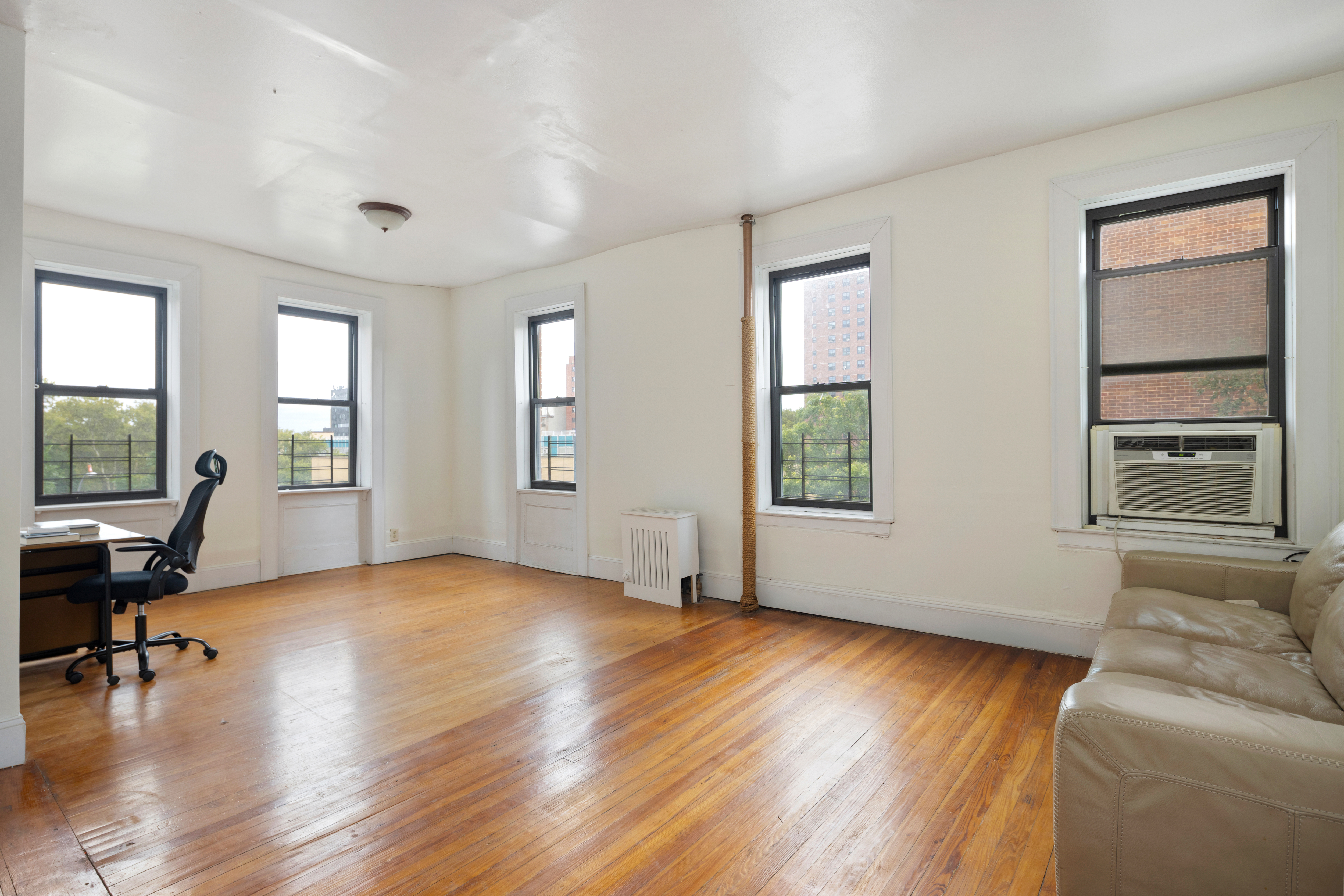 a view of livingroom with furniture hardwood floor and windows