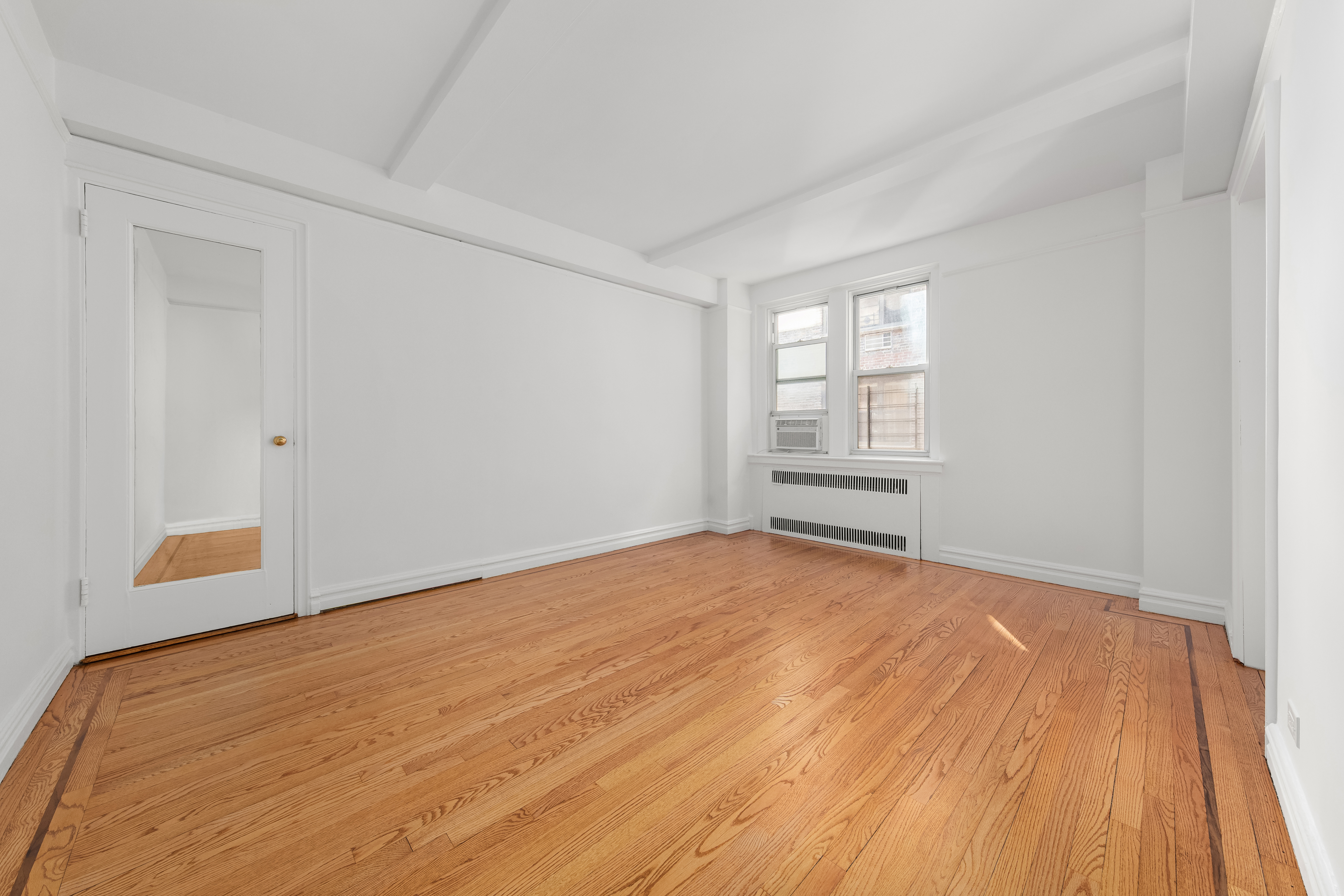 110 East 87th Street, Unit 5C Manhattan, NY 10128 - Photo 11 of 13 a view of empty room with wooden floor and fan