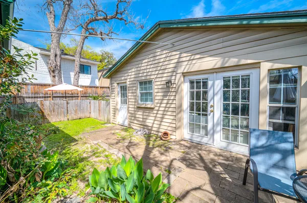 a view of a backyard with table and chairs and wooden fence
