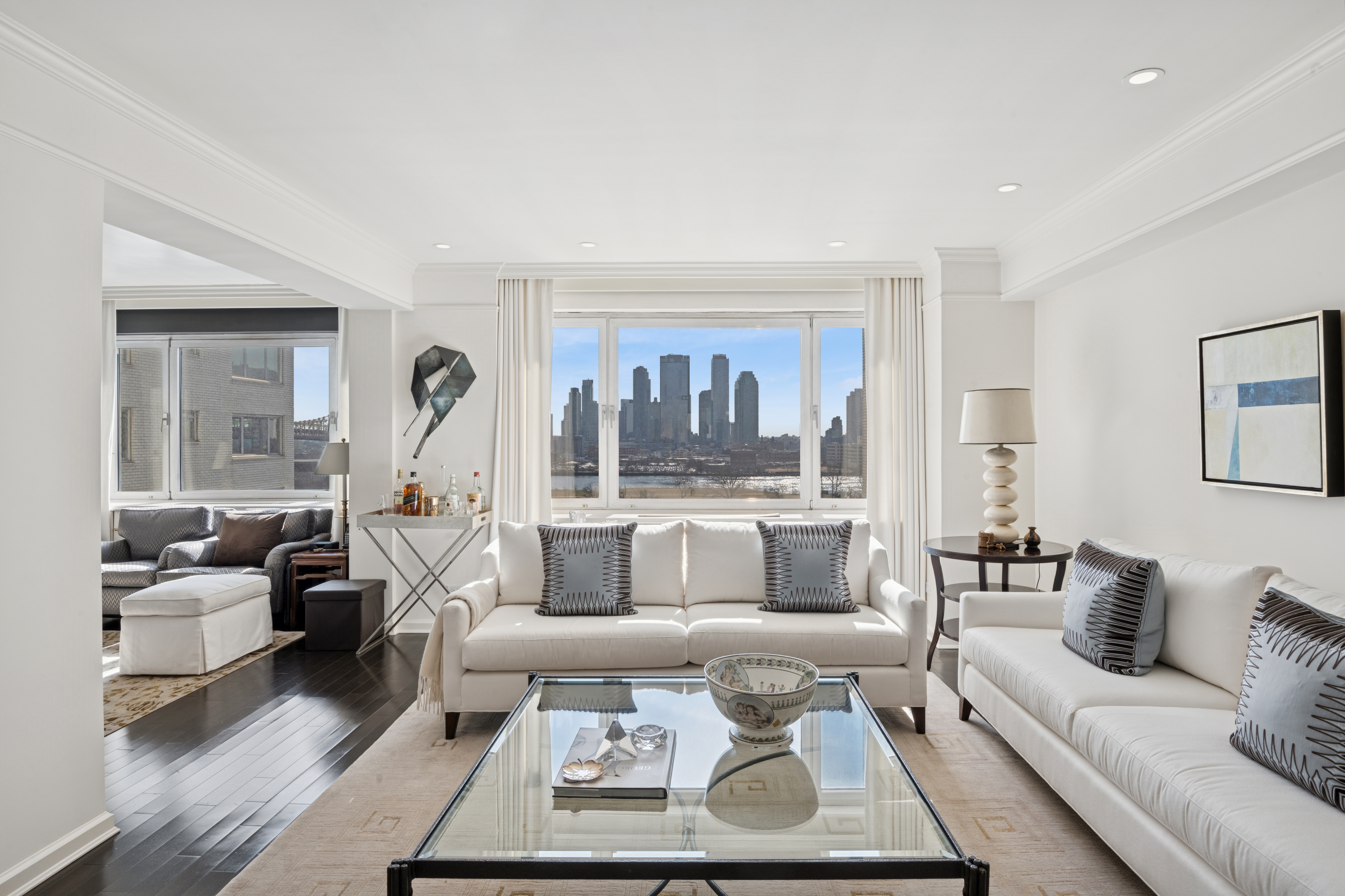 45 Sutton Place South, Unit 12I Manhattan, NY 10022 - Photo 1 of 14 a living room with furniture and a large window
