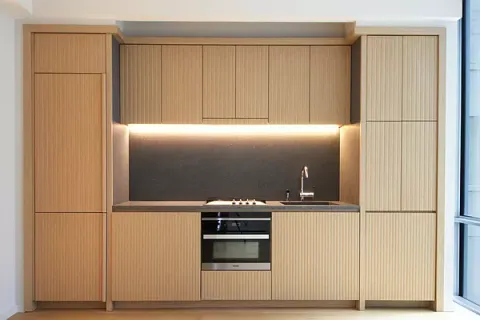 a kitchen with a refrigerator and white cabinets