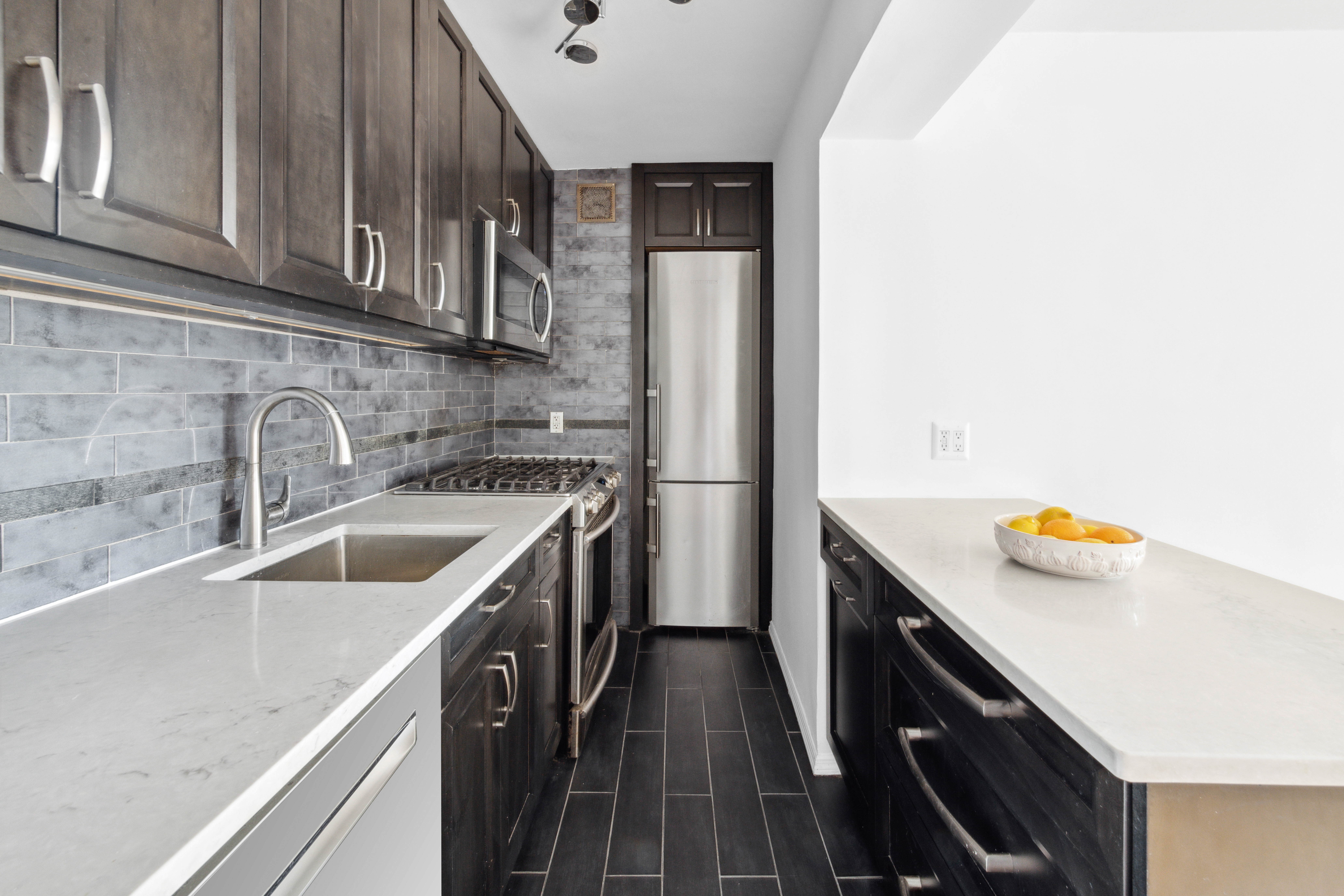 229 East 28th Street, Unit 6D Manhattan, NY 10016 - Photo 3 of 6 a kitchen with a sink a stove and cabinets