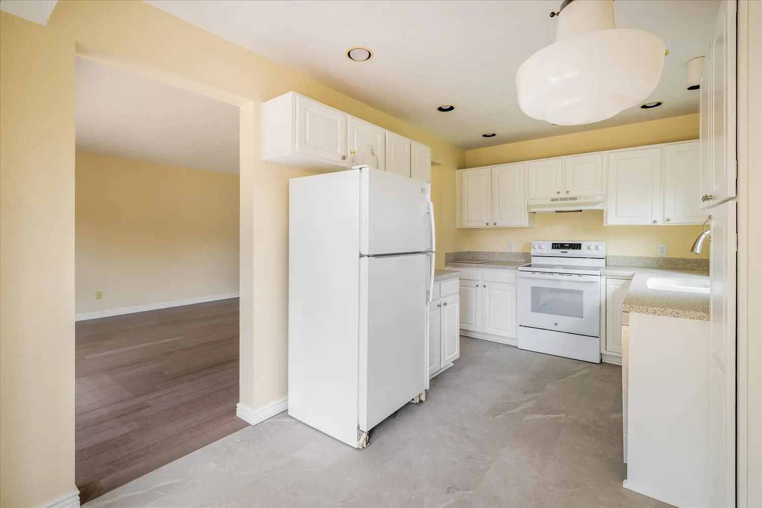 a kitchen with white cabinets and white appliances