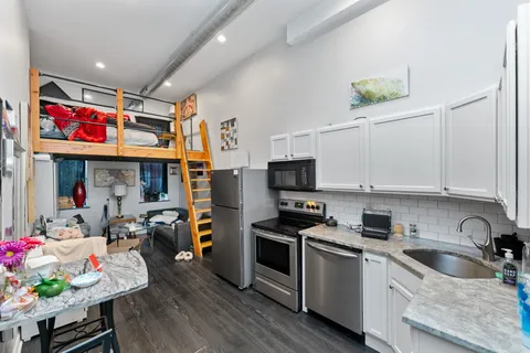a kitchen with stainless steel appliances a refrigerator sink and wooden floor