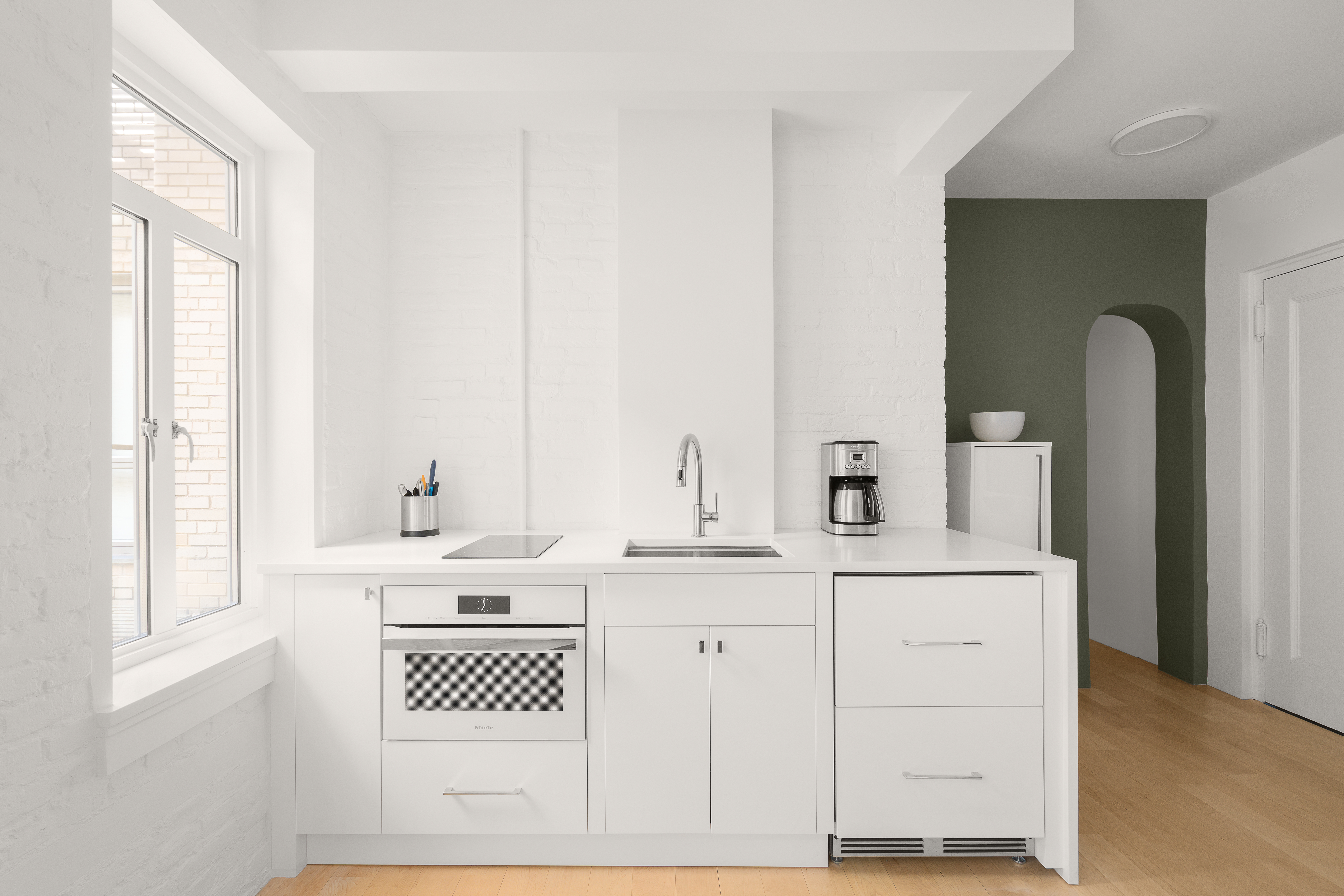 165 West 20th Street, Unit 5F Manhattan, NY 10011 - Photo 4 of 7 a kitchen with white cabinets and white appliances