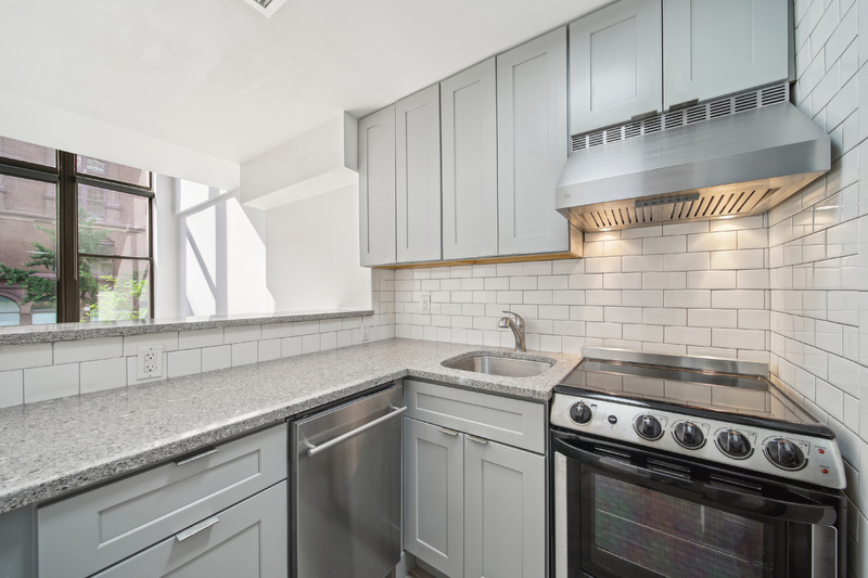 65 Cooper Square, Unit 2A Manhattan, NY 10003 - Photo 5 of 13 a view of a kitchen with sink wooden cabinets and entryway